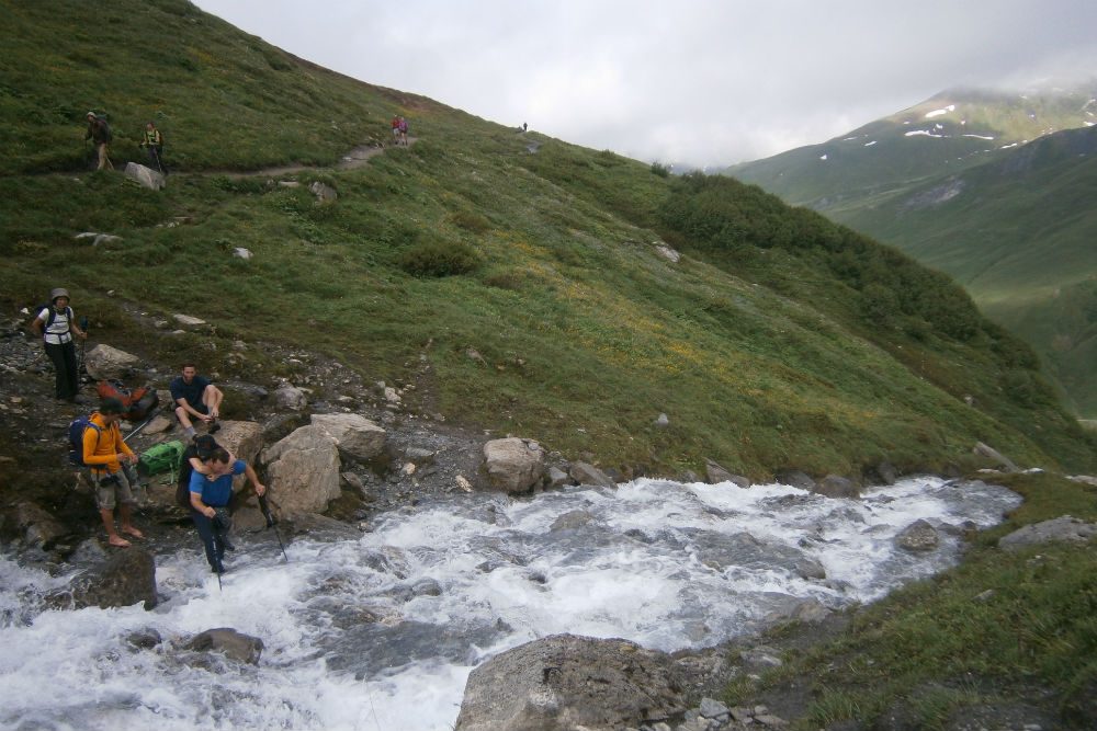 Crossing a stream on the Tour de Mont Blanc hiking trail
