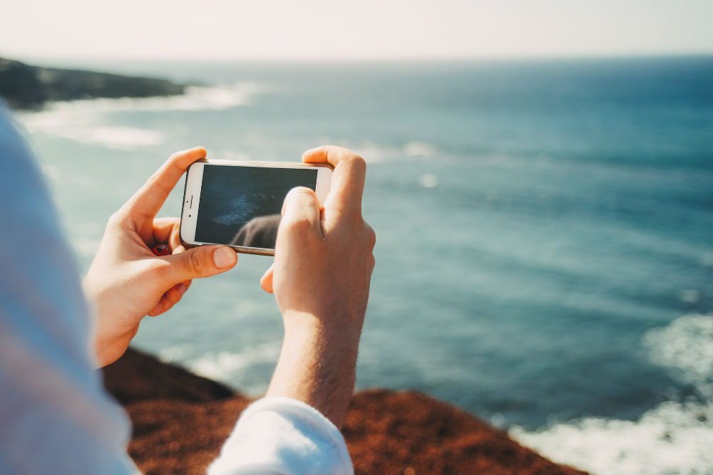 smartphone taking picture ocean beach