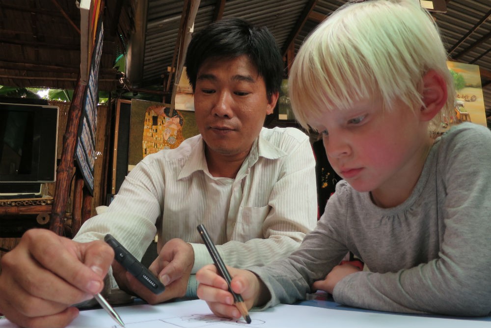 local artist and kid sketching in Mekong Delta