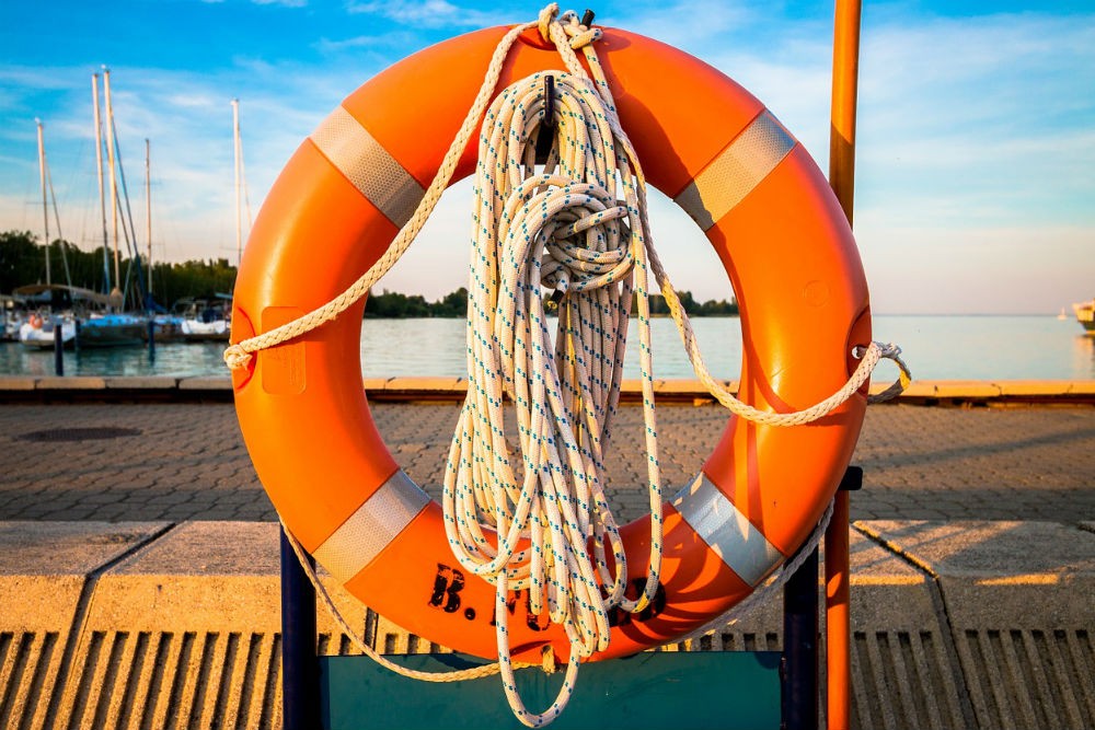 orange life preserver on hook at lake