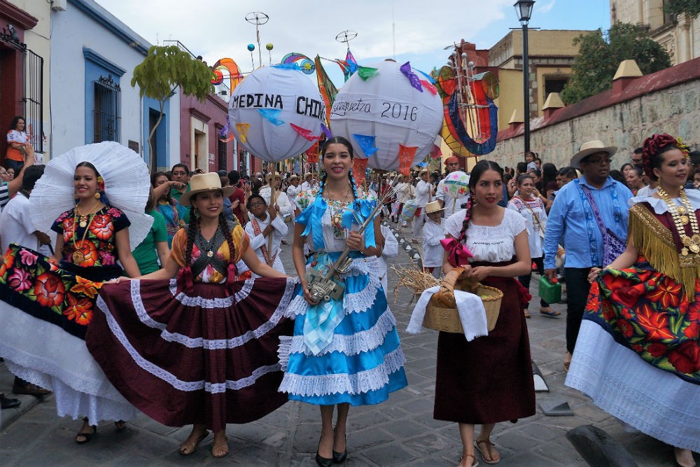 people parading in Oaxaca street for La Guelaguetza, one of Mexico's most colorful festivals