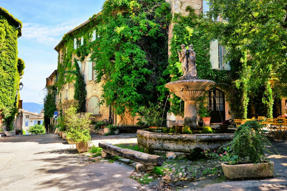 Leafy town square with fountain in a picturesque village in Provence, France