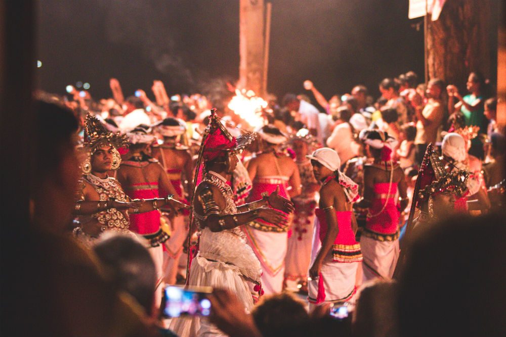 people dancing in traditional costumes at the Kandy Festival in Sri Lanka