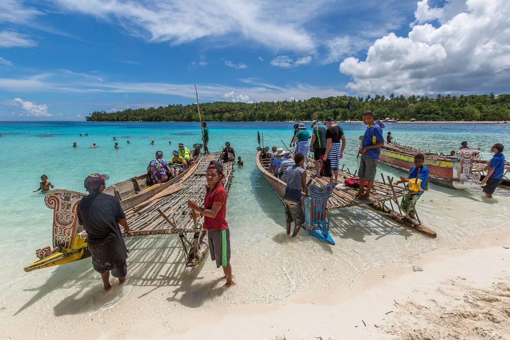 mean with lakatoi boats on beach of Papua New Guinea