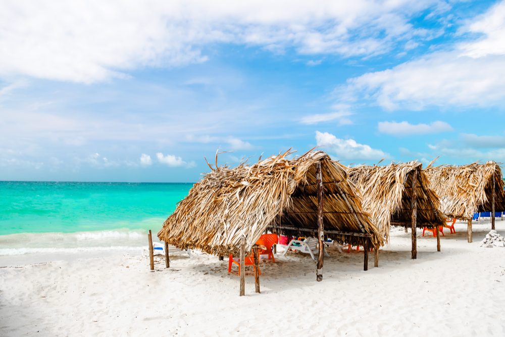 thatched bungalows on a white sand beach on Isla Baru, Colombia
