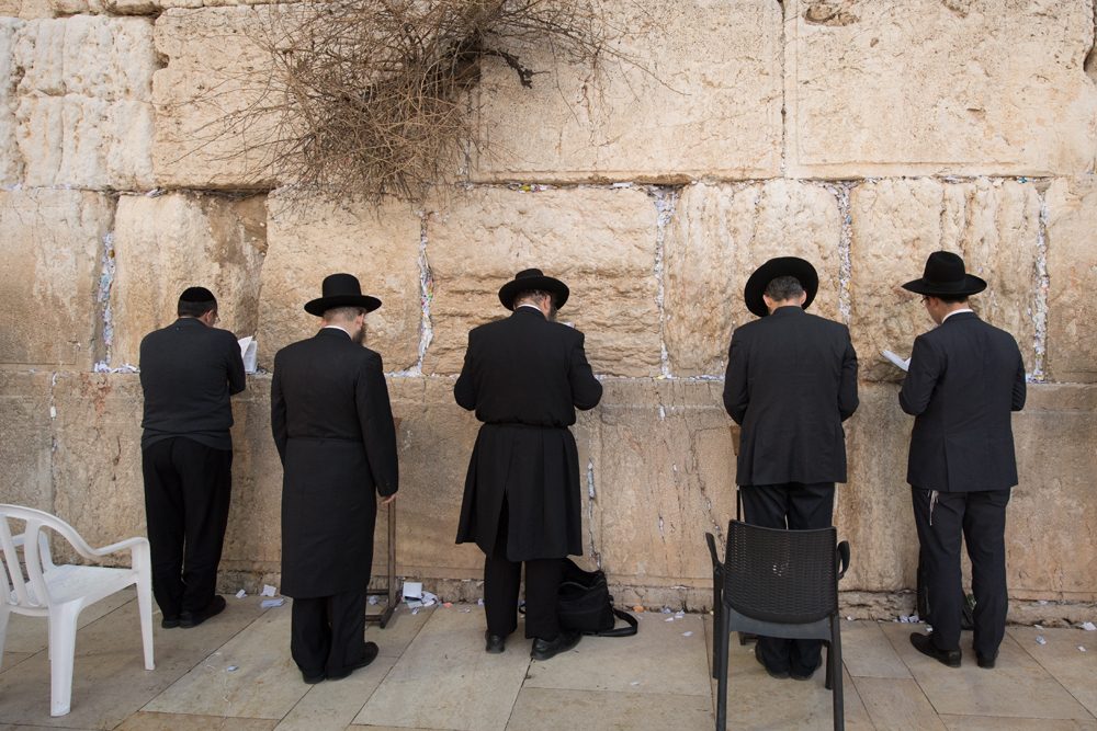 Men praying at the Western Wall Jerusalem Israel