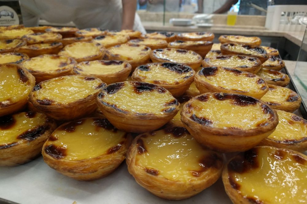 stacks of Portuguese egg tarts on display at a bakery in Lisbon Portugal