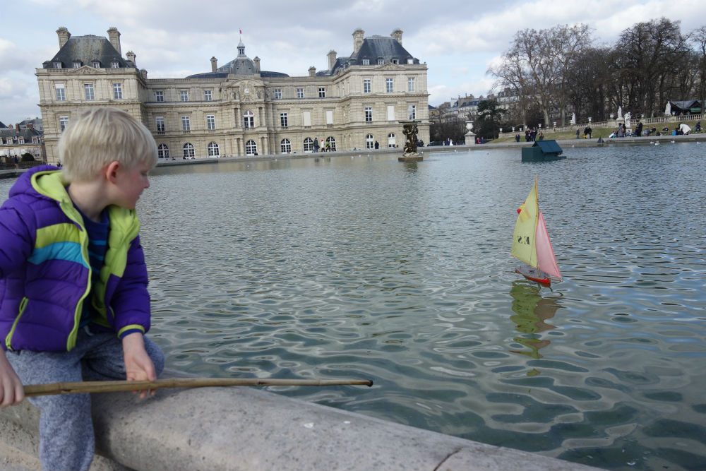 Sailing a toy boat on the Luxembourg Gardens' pond in Paris