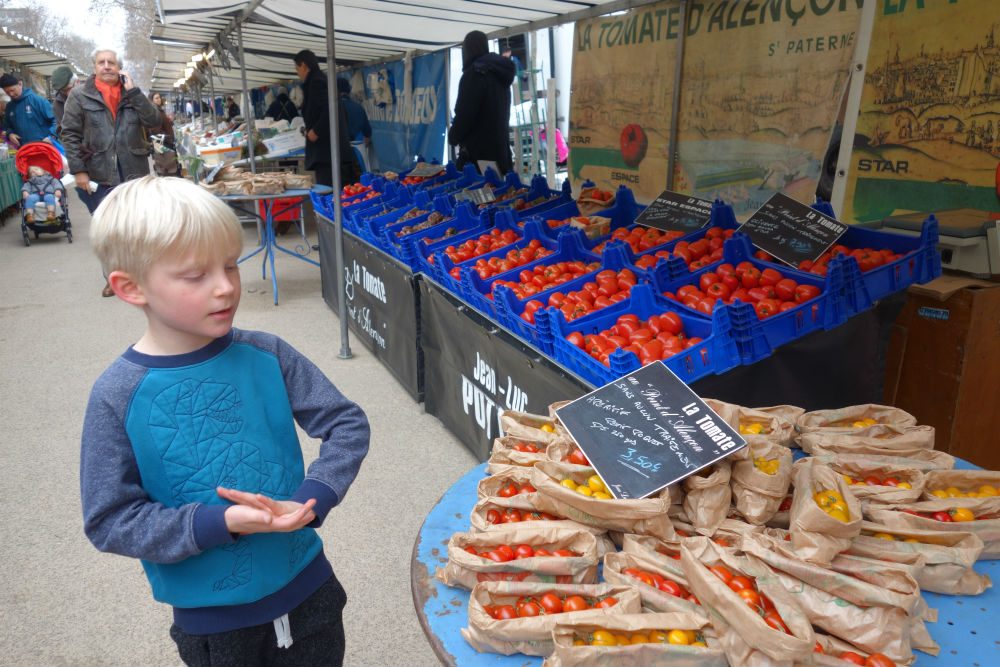 boy at market Marché Saxe-Breteuil in Paris