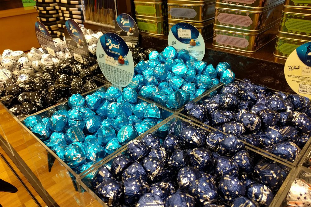 piles of Baci chocolate kisses in bins at the Perugina chocolate factory in Perugia Italy