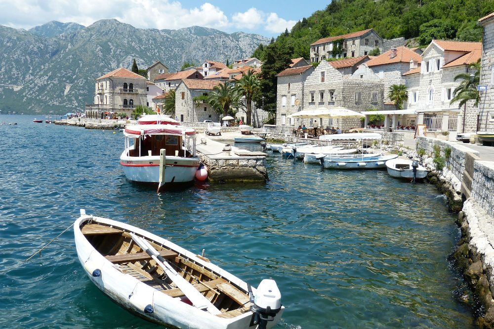 coast of Kotor Montenegro village with boats water and mountains