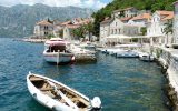 coast of Kotor Montenegro village with boats water and mountains