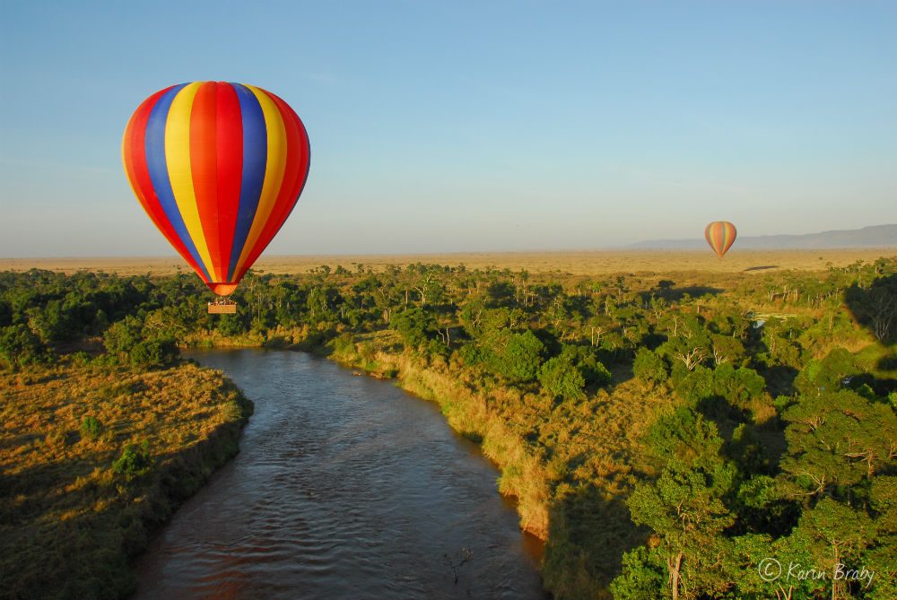 Hot air balloons rise over Angama Mara safari lodge in Kenya