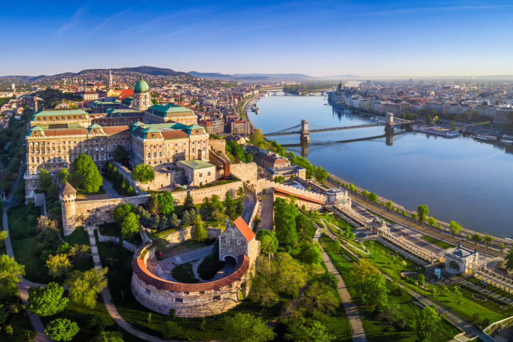 Budapest, Hungary - Aerial panoramic skyline view of Buda Castle Royal Palace with Szechenyi Chain Bridge, St.Stephen's Basilica, Hungarian Parliament and Matthias Church at sunrise with blue sky