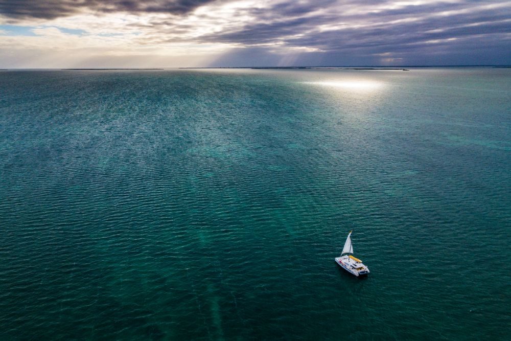 aerial shot of Belize ocean with sailboat