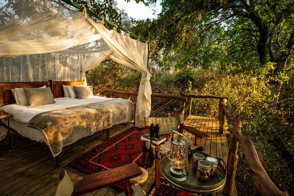 outdoor bedroom at safari lodge Sapi Explorers Camp in Zimbabwe