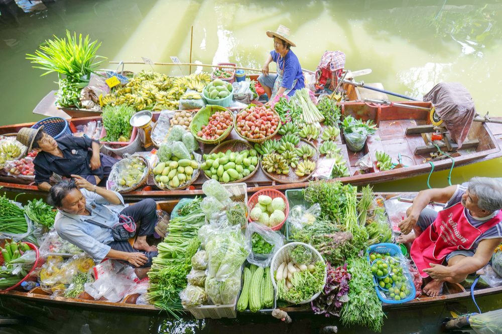 Floating market Traders bring fruits and vegetables to a small boat engine sold to the canal in Bangkok Thailand