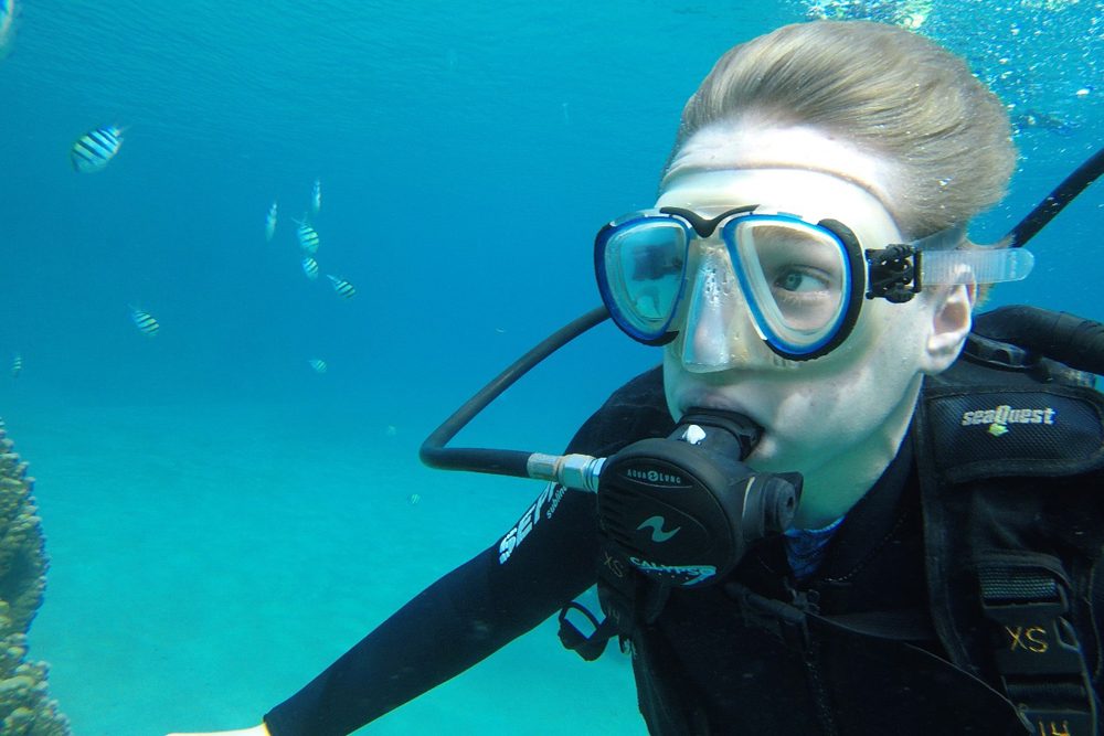 teenage boy scuba dives in Israel