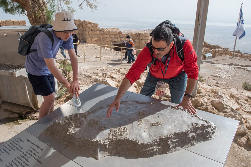 guide pointing at 3-D model of Masada fortress Israel