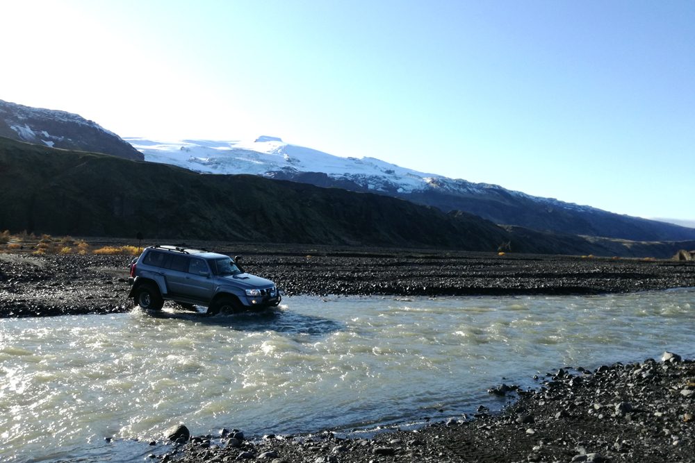 A super jeep crosses a river in Thorsmork Valley.