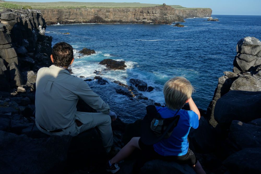 Galapagos Cruise boy spotting seabirds off coast