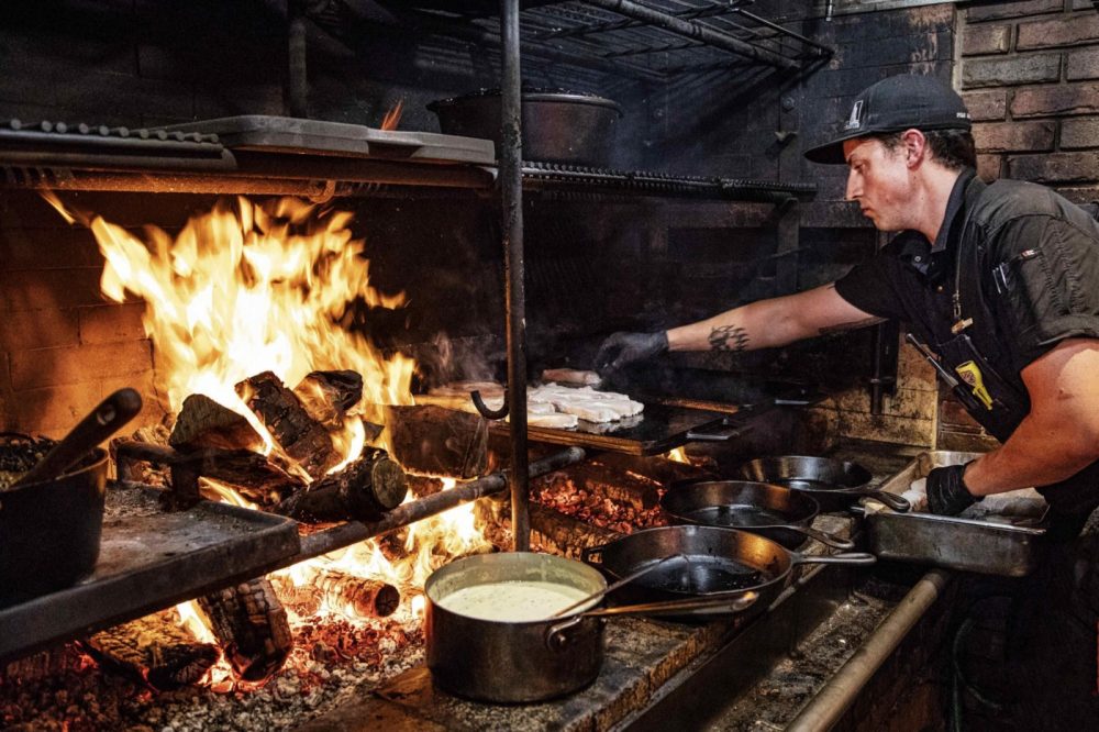 chef cooking over fire at Inn at Bay Fortune Prince Edward Island Canada