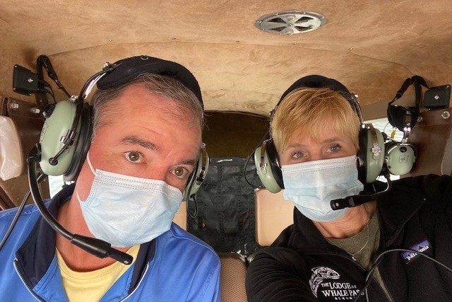 traveler couple wearing masks in a float plane in Alaska