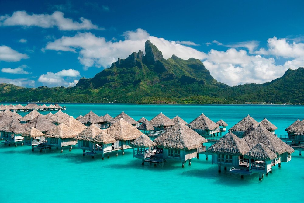 overwater bungalows at St. Regis Bora Bora with mountain in background