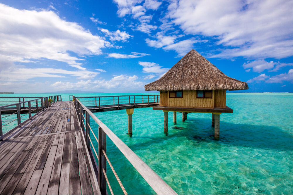 overwater bungalow and dock over turquoise water in Bora Bora, French Polynesia