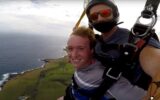 teenage boy tandem skydiving selfie over Hawaii