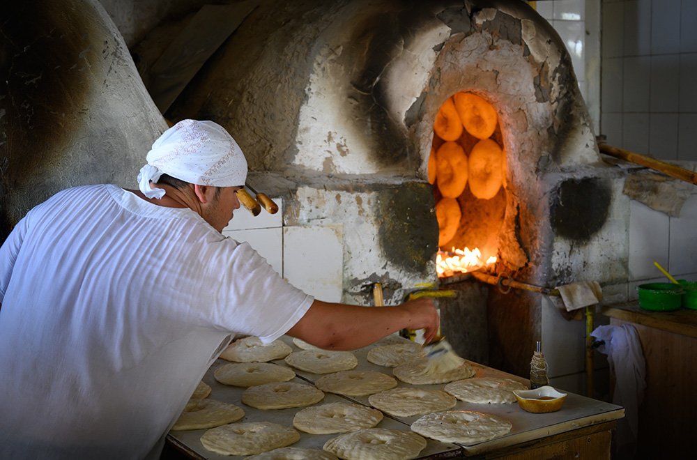 baker baking bread in oven in Uzbekistan