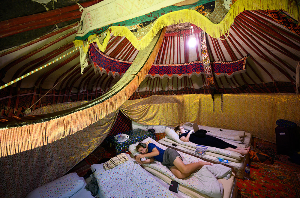 two teenage tourist boys resting inside a yurt at a yurt camp in Uzbekistan