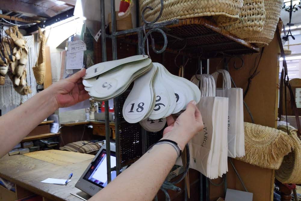 queue ticket numbers in shape of shoes at La Manual Alpargatera, oldest espadrilles shop in Barcelona