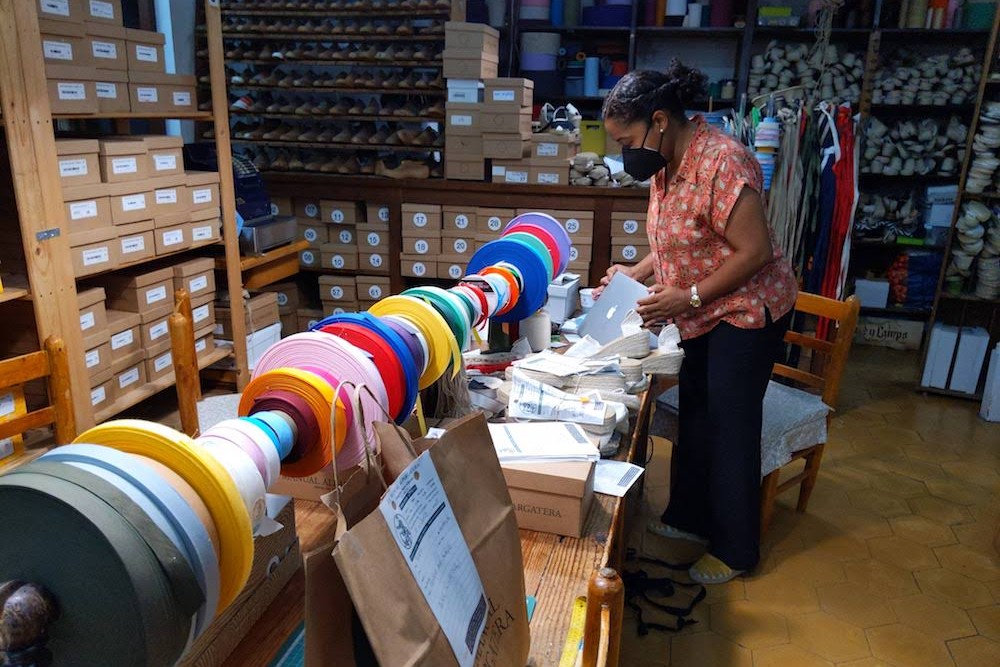 worker at work table at La Manual Alpargatera, oldest espadrilles shop in Barcelona