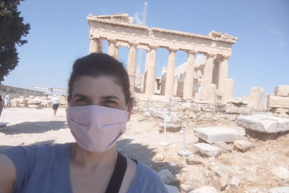 selfie of a woman wearing a mask in front of the Parthenon at the Acropolis in Athens Greece