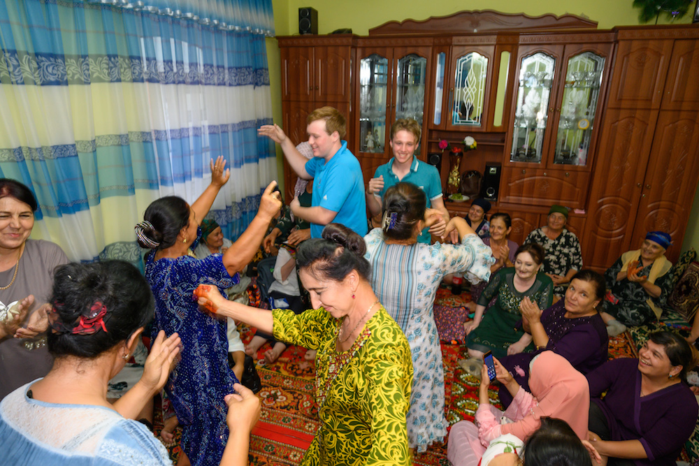 American teenage boys dancing with locals at a family birthday party in Khiva Uzbekistan