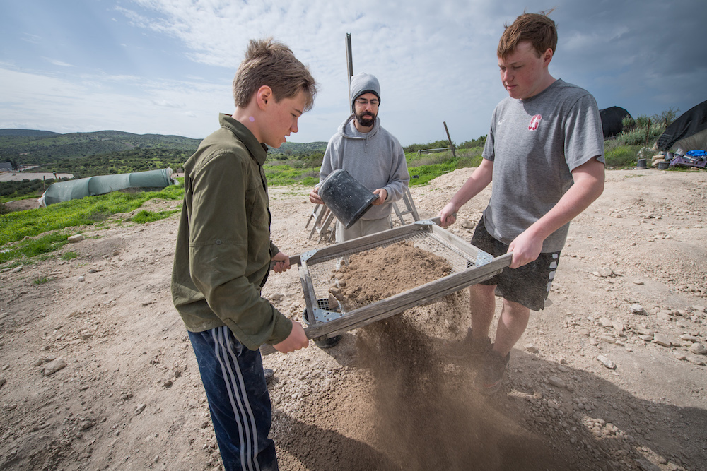 two teenage boy tourist sifting sand for artifacts at Tel Maresha Israel