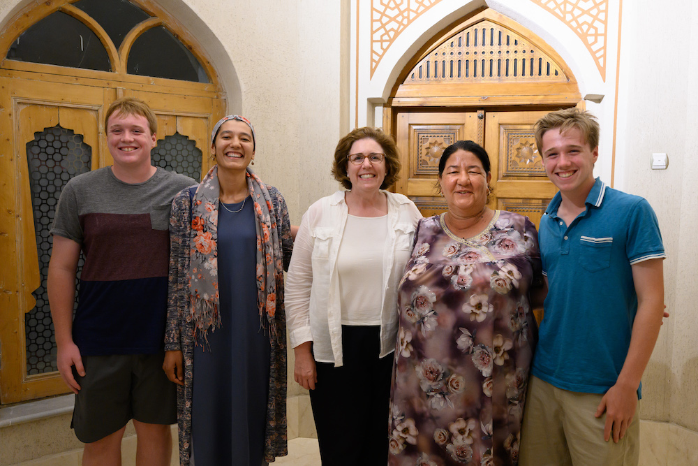 American traveler family poses with a woman in Bukhara Uzbekistan