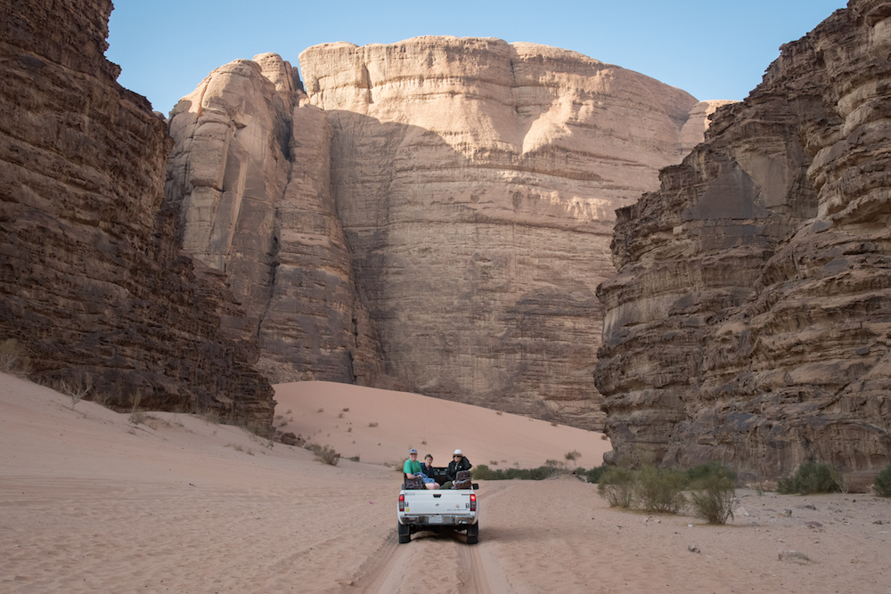 tourist family driving truck in desert of Wadi Rum jordan between two rock walls