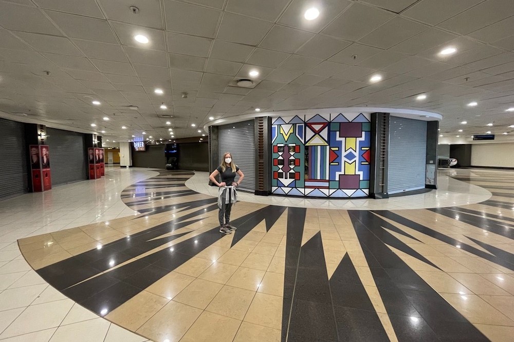 tourist woman standing in Johannesburg South Africa airport with no crowds around during pandemic