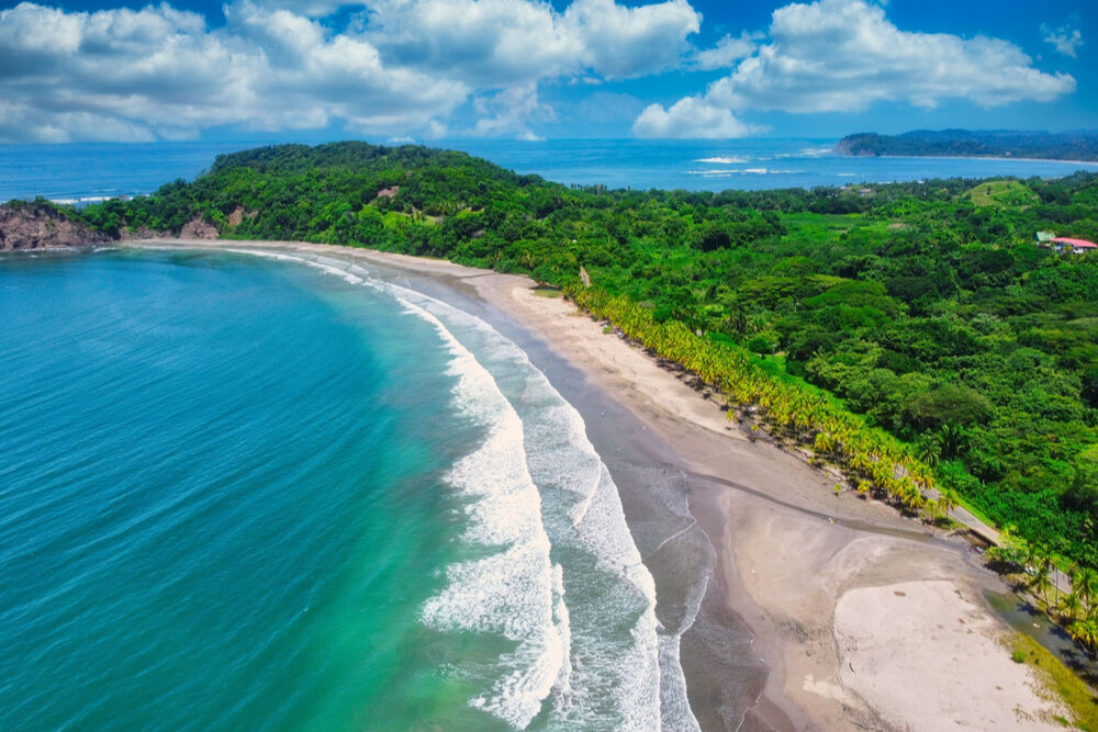 beach, coastline lined with green jungle at Costa Rica Carrillo and Samara Beaches in Costa Rica