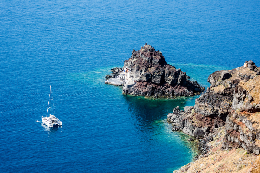 A catamaran anchored off the coast of Santorini, Greece.