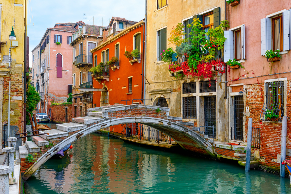 Narrow canal with bridge in Venice, Italy. Architecture and landmark of Venice. Cozy cityscape of Venice.