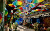 rainbow umbrellas hover over a street of shops and restaurants in Istanbul turkey