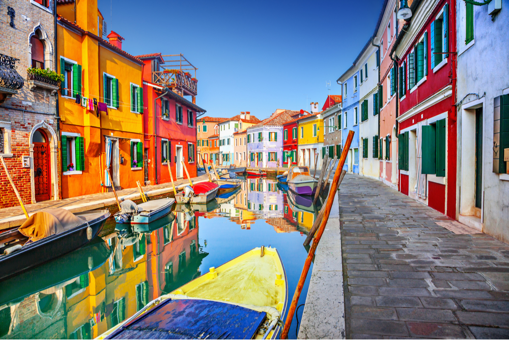 Colorful houses and boat on a canal in Burano, Venice, Italy