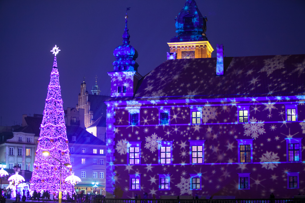 Christmas tree and projected snowflake lights on a building at the Warsaw Christmas market in Warsaw Poland