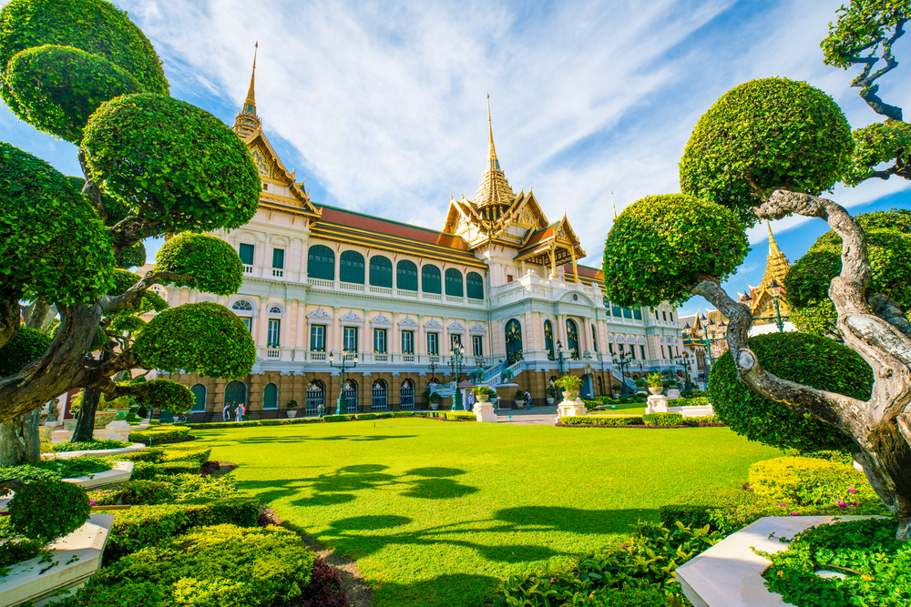 Grand palace in emerald buddhist temple green grass tree field sightseeing travel in Bangkok, Thailand
