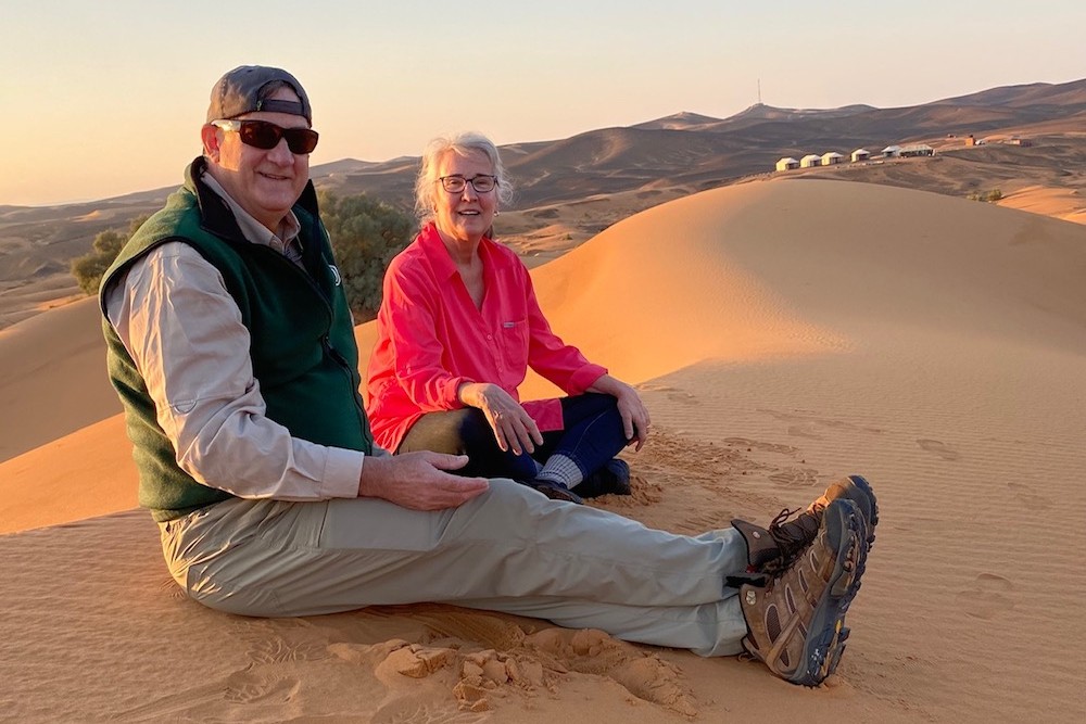 couple sitting on a sand dune in Morocco