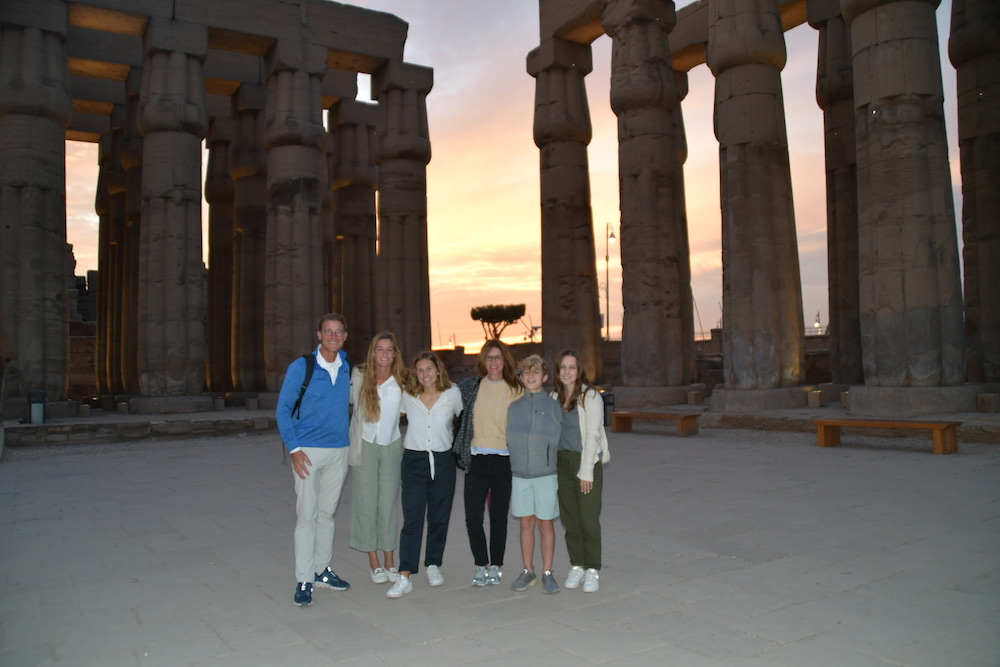 family of travelers at Egyptian temple at sunset