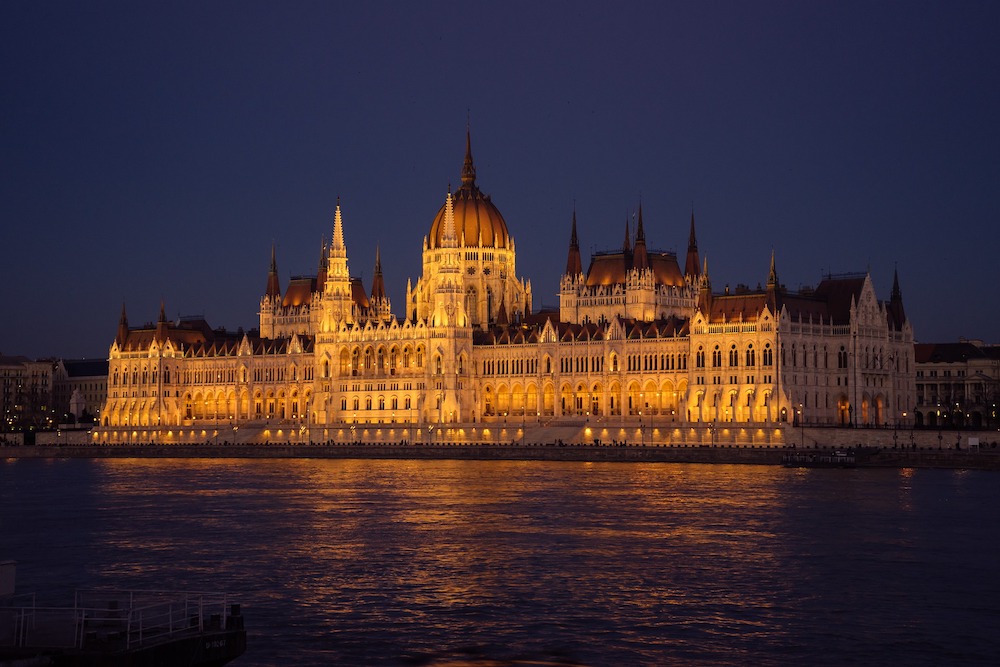 HUngarian Parliament building lit up at night, viewed from the Danube River Hungary